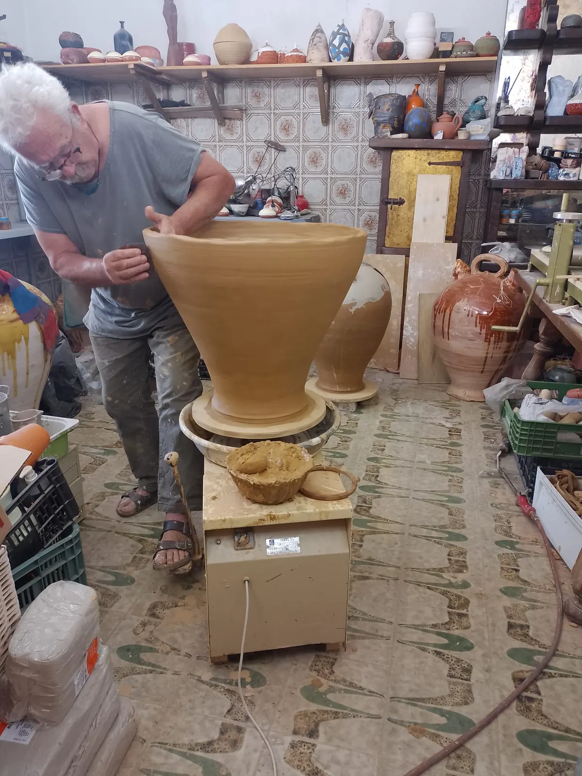 Daniel Caselles sujeta con las dos manos una pieza cónica de barro de casi un metro en su taller