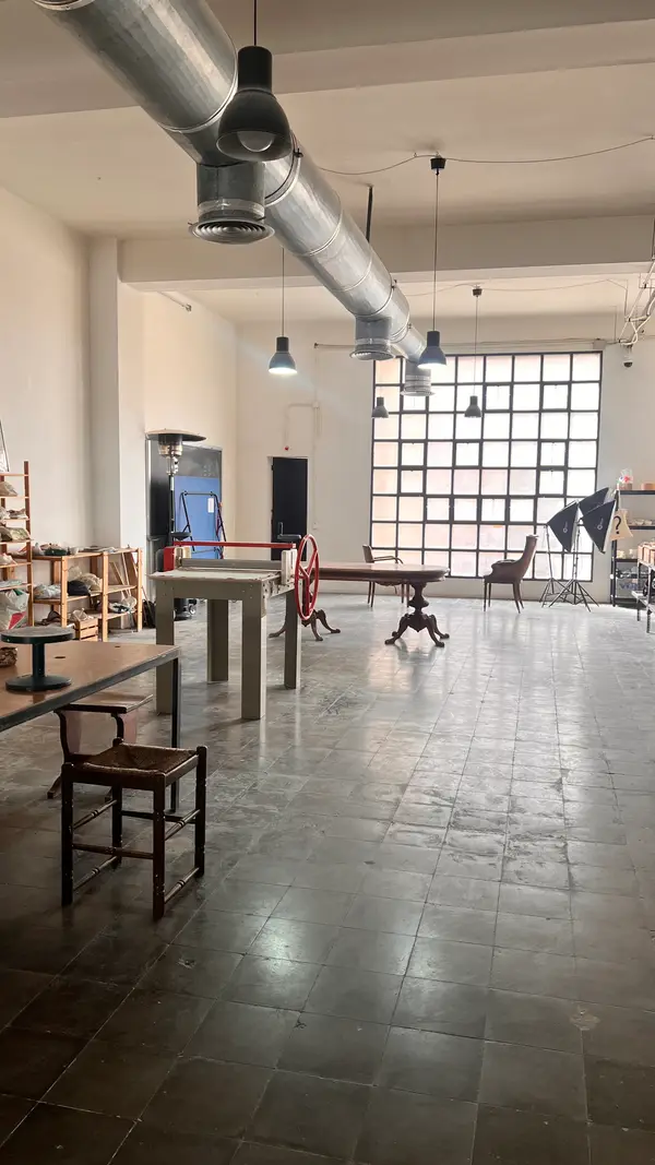 Sala del taller con mesas de trabajo amplias y luz natural entrando por el ventanal